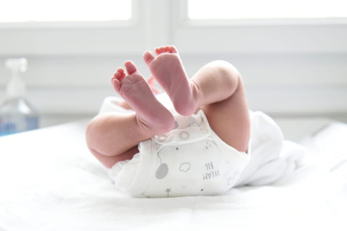 Séance d’ostéopathie pédiatrique, mains de la praticienne sur un nourrisson